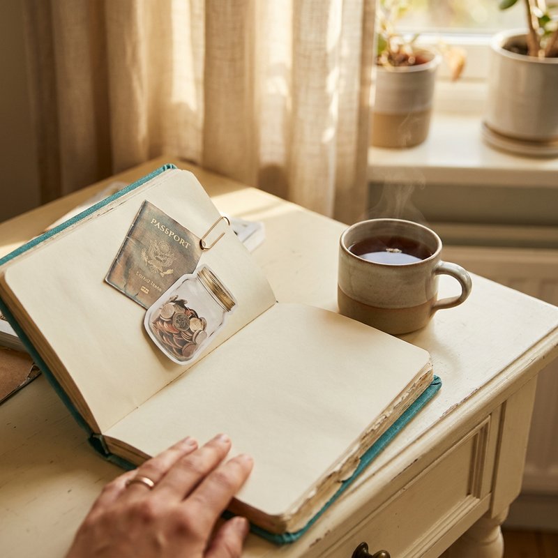 Vision board with handwritten money goals pinned above a desk